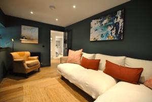 a living room with a white couch and a chair at Kittiwake Cottage- stunning coastal cottage in Anstruther