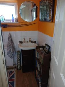 a small bathroom with a sink and a mirror at 2 Little Meadow Cottages in Dartmouth +26 photos