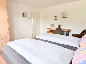 a bedroom with two beds and a desk with a desk at Entspannung und Erholung, Ferienwohnung mit traumhaftem Blick in die Natur in Oberaurach