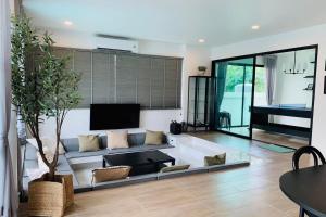 a living room with a couch and a tv at Live With Passion Pool Villa in Pak Chong