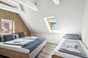 two beds in a room with white walls and wooden floors at Harzquelle - Harzauszeit 2-4 Personen mit Garten in Thale