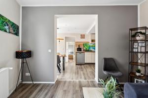a living room with white walls and wooden floors at Harzquelle - Harzauszeit 2-4 Personen mit Garten in Thale