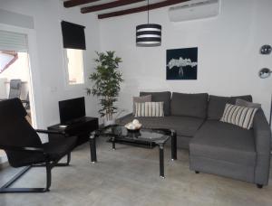 sala de estar con sofá y mesa en Málaga Apartamentos - Nuño Gómez, 24, en Málaga