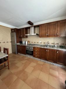 a large kitchen with wooden cabinets and a table at Casa La Torera in Isora