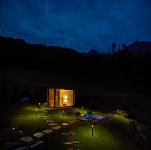 a small cabin in the middle of a yard at night at Heritage Carrel in Valtournenche