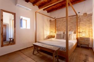 Schlafzimmer mit Himmelbett und Spiegel in der Unterkunft Agroestancia Can Toni Puig in La Mola