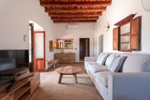 ein Wohnzimmer mit Sofa und Tisch in der Unterkunft Agroestancia Can Toni Puig in La Mola