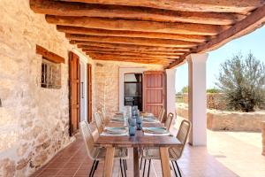 ein langer Holztisch auf einer Terrasse mit Stühlen in der Unterkunft Agroestancia Can Toni Puig in La Mola
