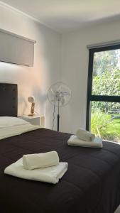 a bedroom with a bed with two towels on it at Casa Fresno Casas Atahualpa 2 in Mar del Plata