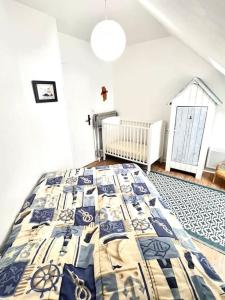 a bedroom with a bed with a quilt on it at La Maison Rose - avec grand jardin clos à 300m de la mer in Hauteville-sur-Mer