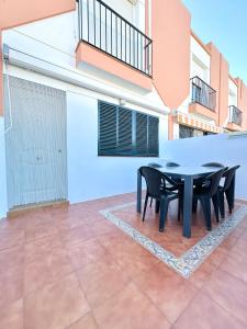 eine Terrasse mit einem schwarzen Tisch und Stühlen darauf in der Unterkunft Casa 3 dormitorios La Barrosa in Chiclana de la Frontera