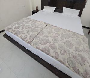 a bed with a blanket on top of it at Parmeshwar Lodge in Tuljapur +6 photos