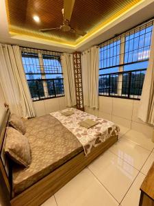 a bedroom with a bed in a room with windows at #1BHK Studio Apartment with 3-4 person occupancy Family only in Mangalore