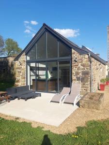 a group of chairs sitting in front of a building at Gîte détente Domaine de Helles -Spa Privatif et Sauna in Poullaouen