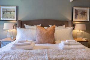 a bed with white blankets and pillows on it at Danes Cottage - Luxury Peak District Retreat in Chapel en le Frith