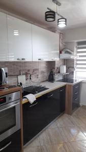 a kitchen with white cabinets and a stove at Apartament de lux cu 3 camere in Bacău