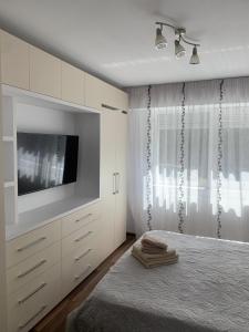 a bedroom with a tv and a bed with a bed sqor at Apartament de lux cu 3 camere in Bacău