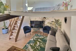 a living room with a couch and chairs and a fireplace at Jungle Loft Béziers centre in Béziers