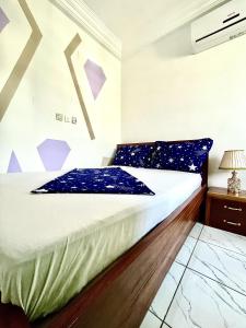 a bedroom with a bed with blue pillows on it at Studio B4 B-ssadi Santa Lucia wifi canal gardien in Douala