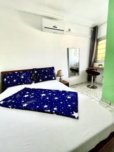 a bed with a blue comforter with stars on it at Studio B4 B-ssadi Santa Lucia wifi canal gardien in Douala +9 photos