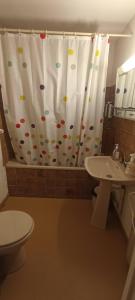 Un baño con cortina de ducha con inodoro y lavabo. en Ax 3 domaines, en Ax-les-Thermes