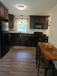 a kitchen with black cabinets and a wooden table at Adorable 1 bedroom with off-street parking in Northbridge