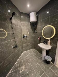 a bathroom with a shower with a sink and a mirror at Luxury apartment in Boulevard Hittin in Riyadh +35 photos