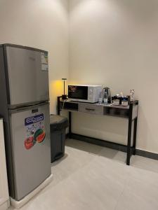 a kitchen with a refrigerator and a microwave at Luxury apartment in Boulevard Hittin in Riyadh
