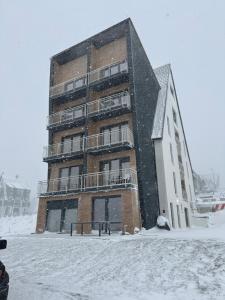 Apartman Zagorac في ديفشيبار: مبنى من الطوب كبير في الثلج في ايزار