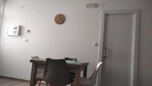 a room with a table and a clock on the wall at Pensión atlantico in Muxia +3 photos