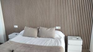 a bed with white sheets and pillows in a bedroom at Pensión atlantico in Muxia
