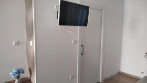a flat screen tv hanging on a wall in a living room at Pensión atlantico in Muxia