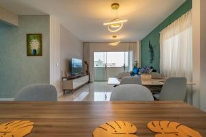 a dining room and living room with a table and chairs at Encantador Apartamento 100m da Praia com vista mar in Porto Belo +38 photos