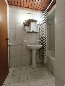 Un baño con lavabo, espejo y bañera. en Plaza Mayor Andrea CENTRO DE MZA, en Mendoza