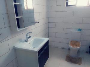 a white bathroom with a sink and a toilet at Phil homes in Accra +19 photos