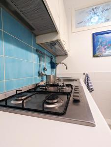 a stove top in a kitchen with a blue wall at Casa Mazzini in Termoli +3 photos