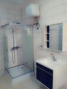 a bathroom with a glass shower and a sink at Phil homes in Accra