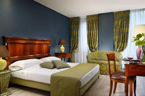 a hotel room with a bed and a chair at Hotel Pierre Milano in Milan