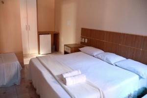 a bedroom with two beds with white sheets at Pousada Cunhantã in Alter do Chao