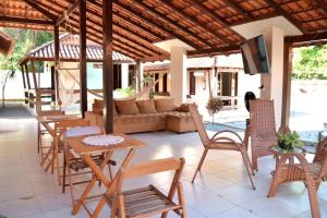 a patio with a couch and tables and chairs at Pousada Cunhantã in Alter do Chao
