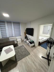 a living room with a couch and a flat screen tv at Make Apartments in Sarajevo