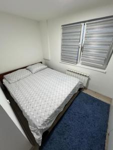 a small bedroom with a bed and a blue rug at Make Apartments in Sarajevo +13 photos