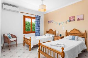 a bedroom with two beds and a chair and a window at Binifortu in Punta Prima +22 photos