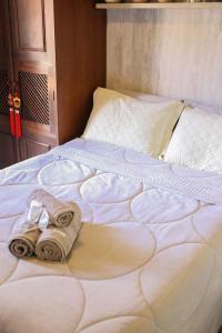 a bed with a towel and towels on it at Casa com Piscina e Área Gourmet em Mury in Muri +68 photos