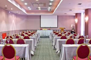 una sala de conferencias con mesas, sillas y una pantalla en Civitel Akali Hotel, en La Canea