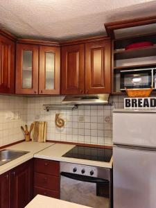 a kitchen with wooden cabinets and a white stove top oven at Prima Casa in Kotor