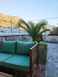 a couch sitting on a patio with a palm tree at Prima Casa in Kotor +20 photos