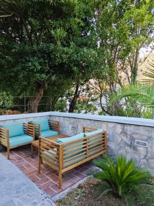 three wooden benches sitting next to a stone wall at Prima Casa in Kotor