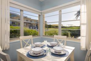a dining room with a table and chairs and windows at Delray Breakers on the Ocean in Delray Beach