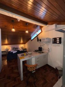 a kitchen with a desk and a bed in a room at Lofts do Pilar - pousada in Ouro Preto